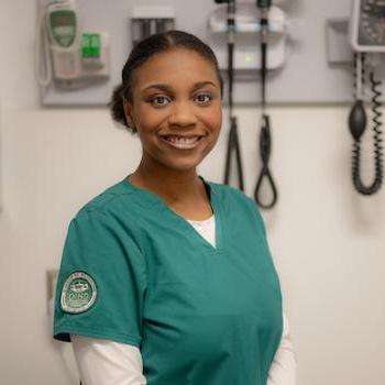 Ohio University nursing student poses while wearing scrubs with an Ohio University patch on the sleeve